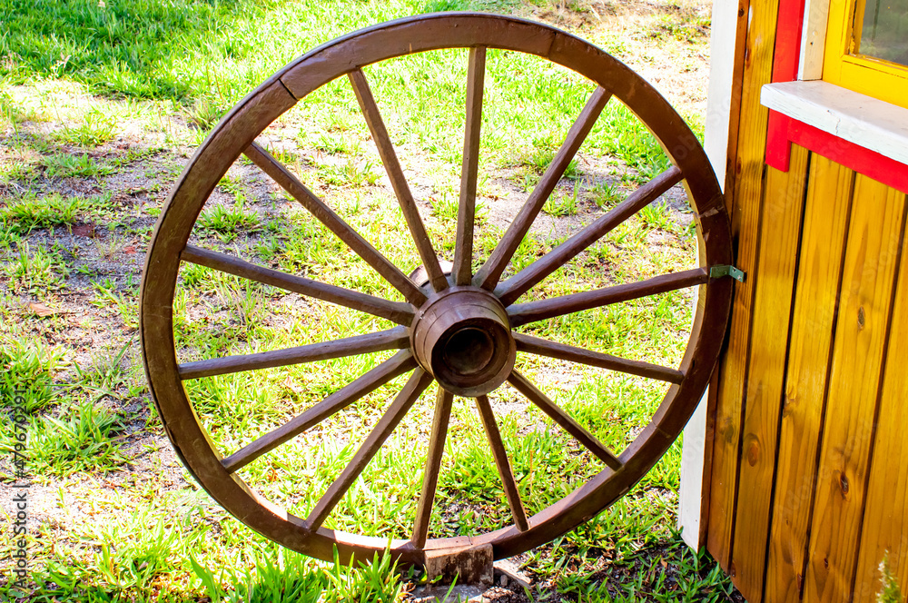 Old cart wheel in children's home, decorative element.