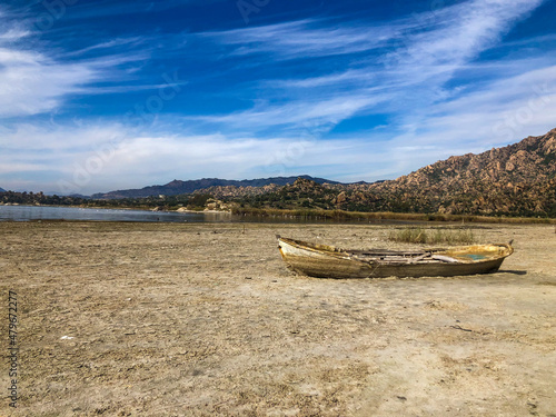 Drought lake and old fishing boat. Old boat on the drought lake. Drought concept. Drought crisis because of global warming. Global warming causes climate change. Drought lake due to global warming.