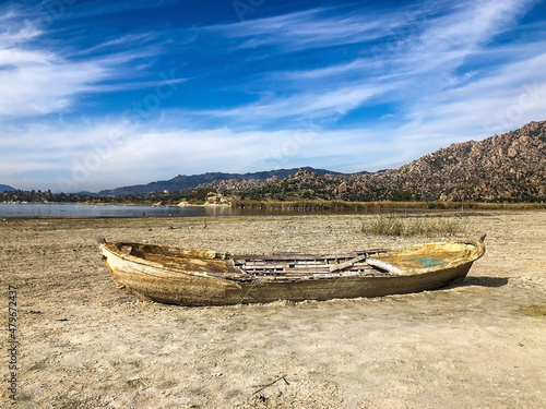 Drought lake and old fishing boat. Old boat on the drought lake. Drought concept. Drought crisis because of global warming. Global warming causes climate change. Drought lake due to global warming.