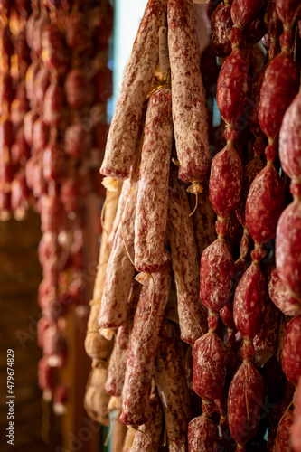 Variety of homemade dried salami sausages hanging in butchery shop in Parma, emilia Romagna, Italy