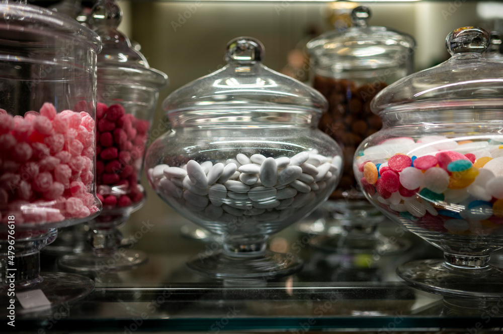 Candy shop display with glass jars filled with jelly candies and bonbons