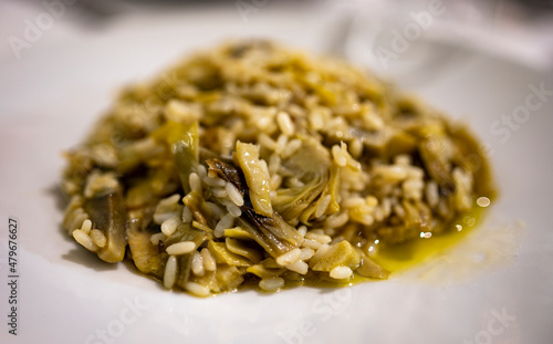 Italian cuisine, fresh vegetarian risotto made with young artichoke heads close up.