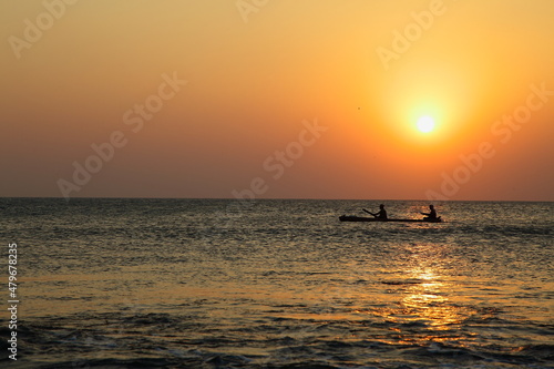 A beautiful sunrise seascape view with fisherman and fishing boats.