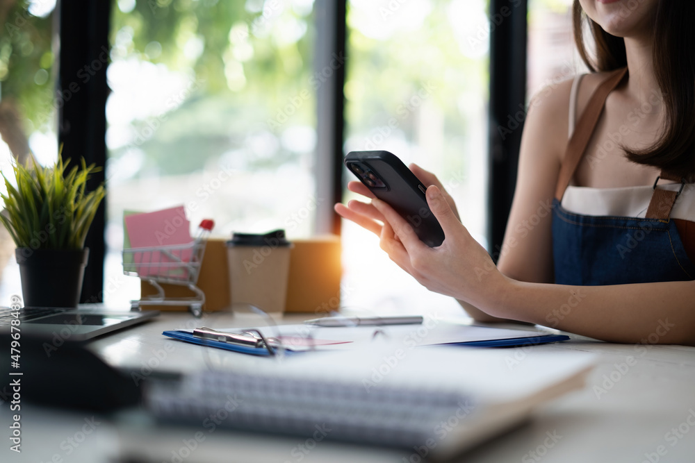 Business owner confirm address to send to customer orders talking by cell phone before pack products. Successful SME entrepreneur concept. Business owner confirm address to send to customer orders talking by cell phone before pack products. Successful SME entrepreneur concept.