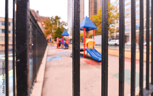Closed playground for kids and pupils during COVID19 pandemic. View of a fence with blurry background. Empty space without children.