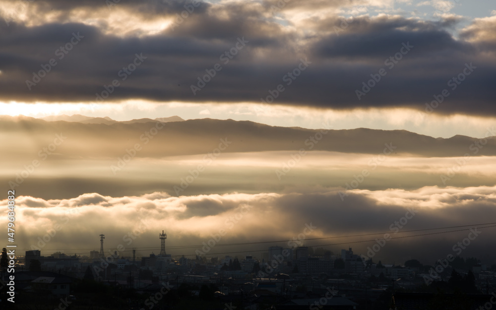 Iida, Nagano, Japan, 2021-11-10 , Clouds lighted by the sun during sunrise in early morning over Iida city, in Nagano, Japan.