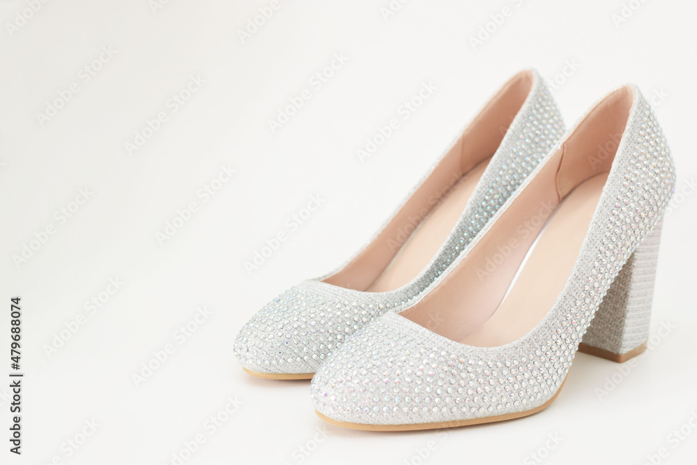 Zapatos plateados de mujer para fiesta. Espacio para texto al lado  izquierdo. Photos | Adobe Stock