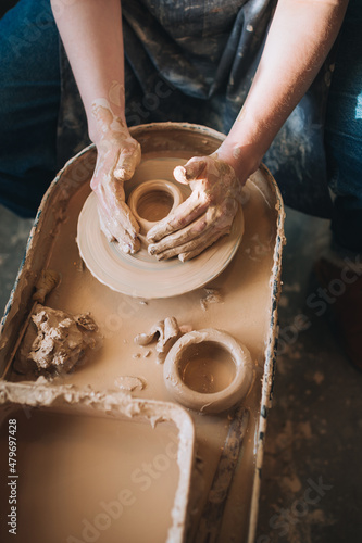 Clay modeling hands on a potter's wheel. Handmade. Ceramic tableware.