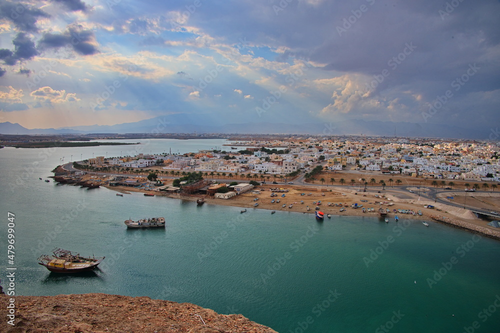 The bay of Sur in Oman with traditional wooden boats and with town in background