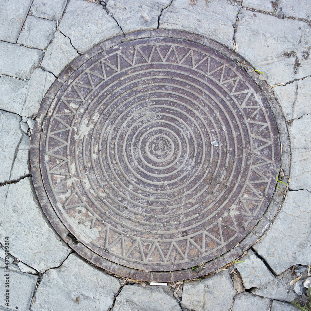 Vintage iron manhole cover with embossed pattern