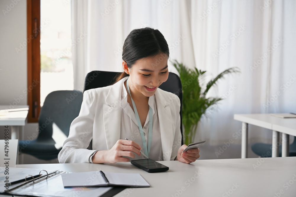 Happy asian businesswoman using smart phone for banking online. Happy asian businesswoman using smart phone for banking online.