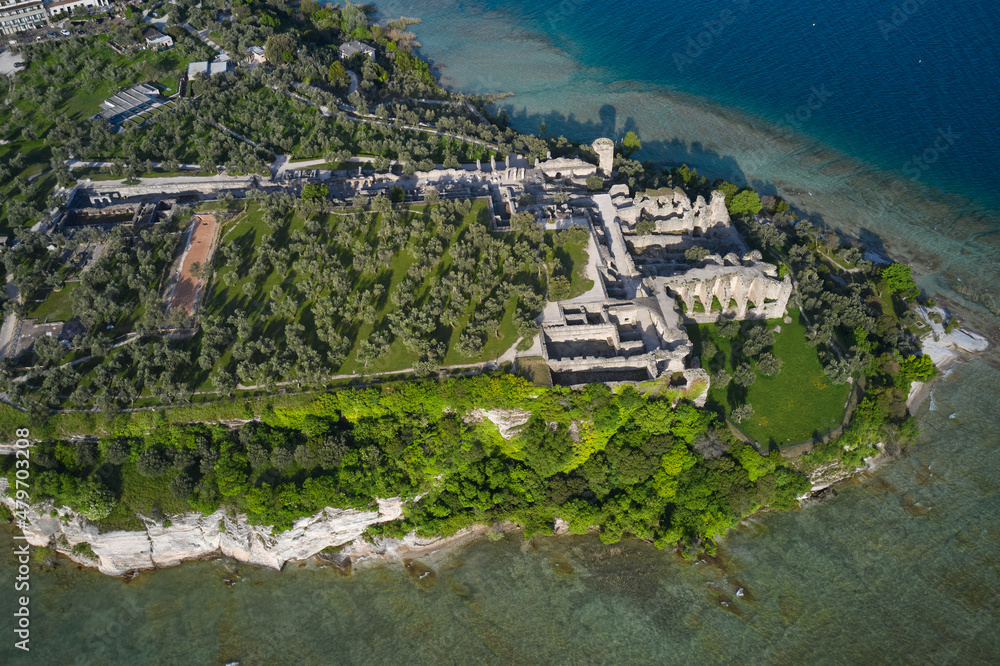 Olive grove and archaeological museum. Aerial view of the Grotte di Catullo ruins of a large Roman villa on the peninsula. Grottoes ruins on the Sirmione peninsula. Lake Garda, Italy.