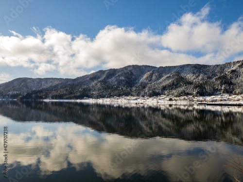 冬の鏡湖にリフレクションする余呉の川並集落と空
