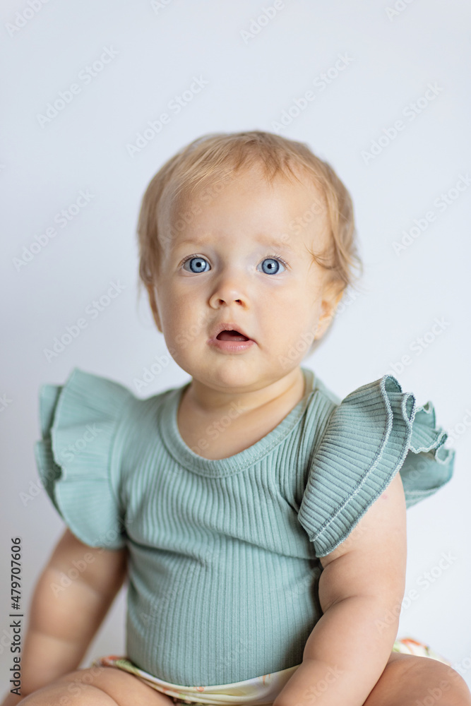 little caucasian baby girl ten months old at home or nursery. Child wearing fashionable clothing 