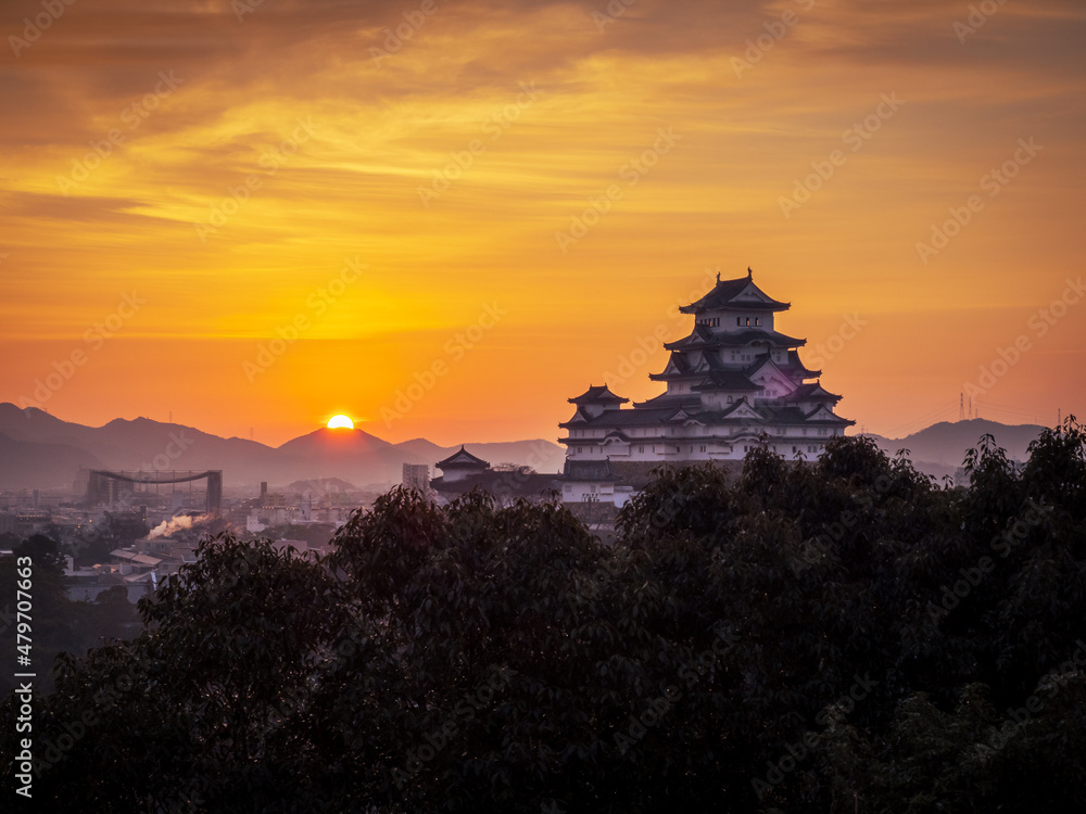 日の出とオレンジの朝焼けに染まる姫路城