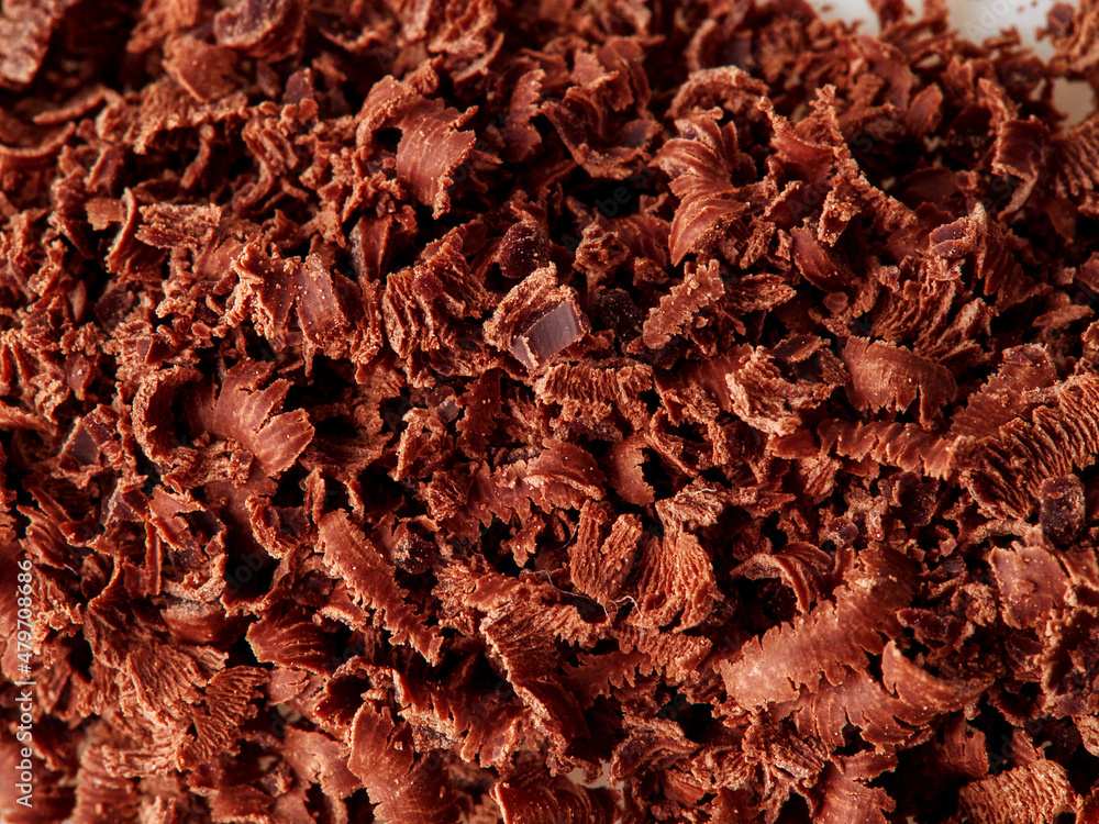 Dark chocolate pieces isolated on white background. Chocolate bar chunks, shavings and cocoa crumbs Top view.