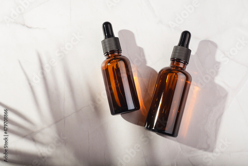 Tableau sur toile Amber glass bottles with dropper pipette with serum or essential oil on a white background