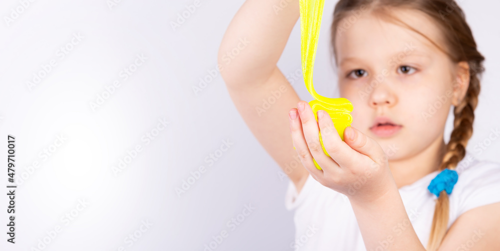 The blonde-haired child is playing with mucus. Little beautiful caucasian girl is playing with yellow slime. Play Slime Toy The blonde-haired child is playing with mucus. Little beautiful caucasian girl is playing with yellow slime. Play Slime Toy