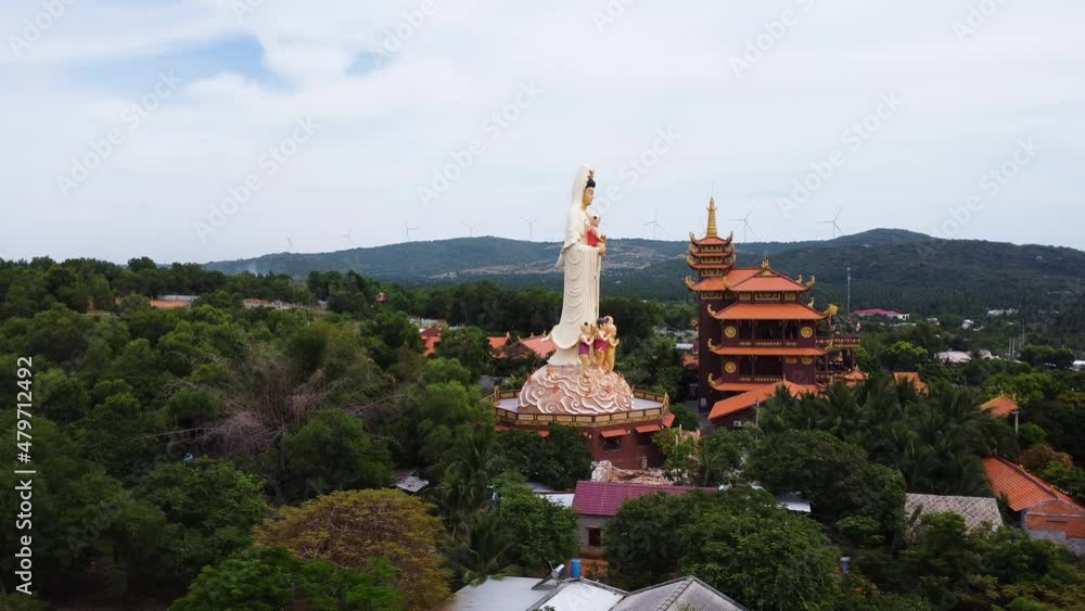 Aerial, buddhist temple with huge statue in the middle of rural palm tree jungle Aerial, buddhist temple with huge statue in the middle of rural palm tree jungle