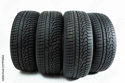 Obraz na płótnie Winter tires rolling forward isolated on white background. Set of four wheel for use in snow and on ice with copy space. Deep pattern in rubber for transportation. w salonie