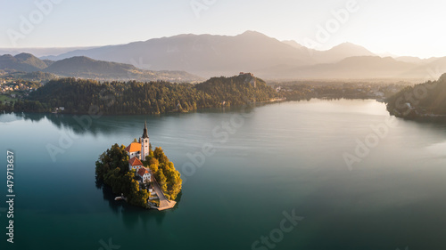 Historical castle on island in tle middle on Bled lake. Panoramic view on tourist destination in Slovenia Julian alps. Famous building in morning sunrise. photo