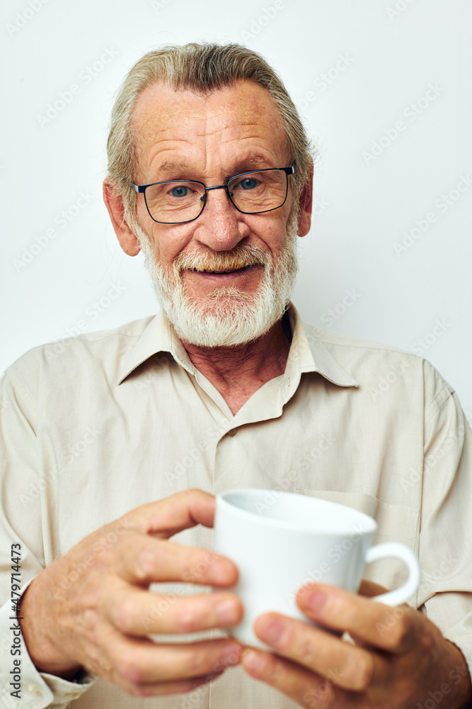 old man in glasses with a mug on a white background joyful old man in glasses with a mug on a white background joyful