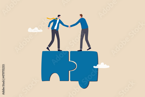 Collaborate, cooperate or partnership and agreement to help business success, together or teamwork support each other concept, success businessmen finish deal and handshake on jigsaw puzzle. photo