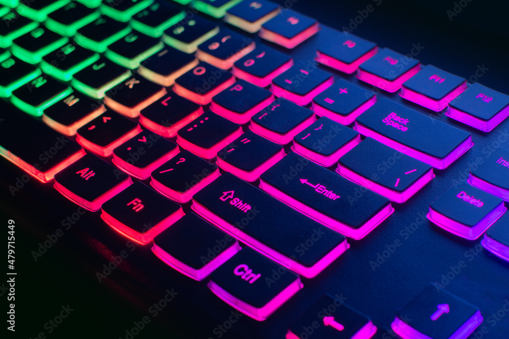 RGB gaming keyboard. Bright colorful keyboard, soft focus. Keyboard with RGB light, blurred background. Close-up.