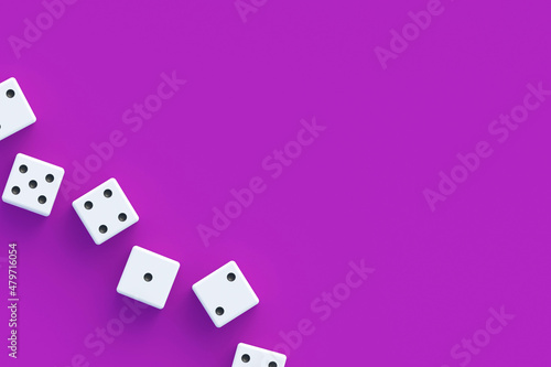 Board games. Addiction to gambling. Casino games. Random winnings. Jackpot. Leisure entertainment for the whole family. Row of dices on violet background. Top view. Copy space. 3d render