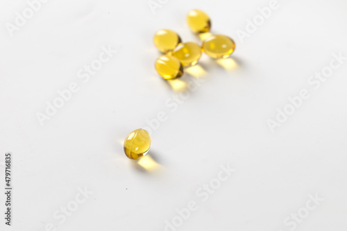 Yellow pills. Omega, vitamin D, Close up. Macro of vitamins on white table