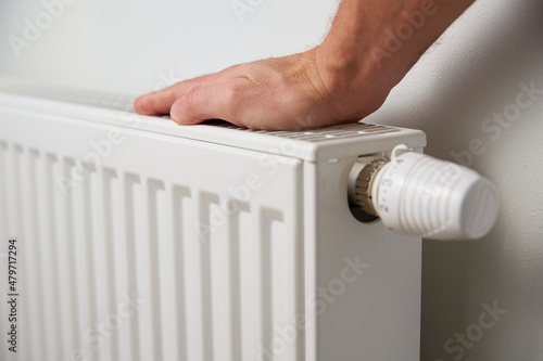 Wallpaper Mural Hand adjusting temperature on heating radiator thermostat, Turning heat radiator knob to control heat in home Torontodigital.ca