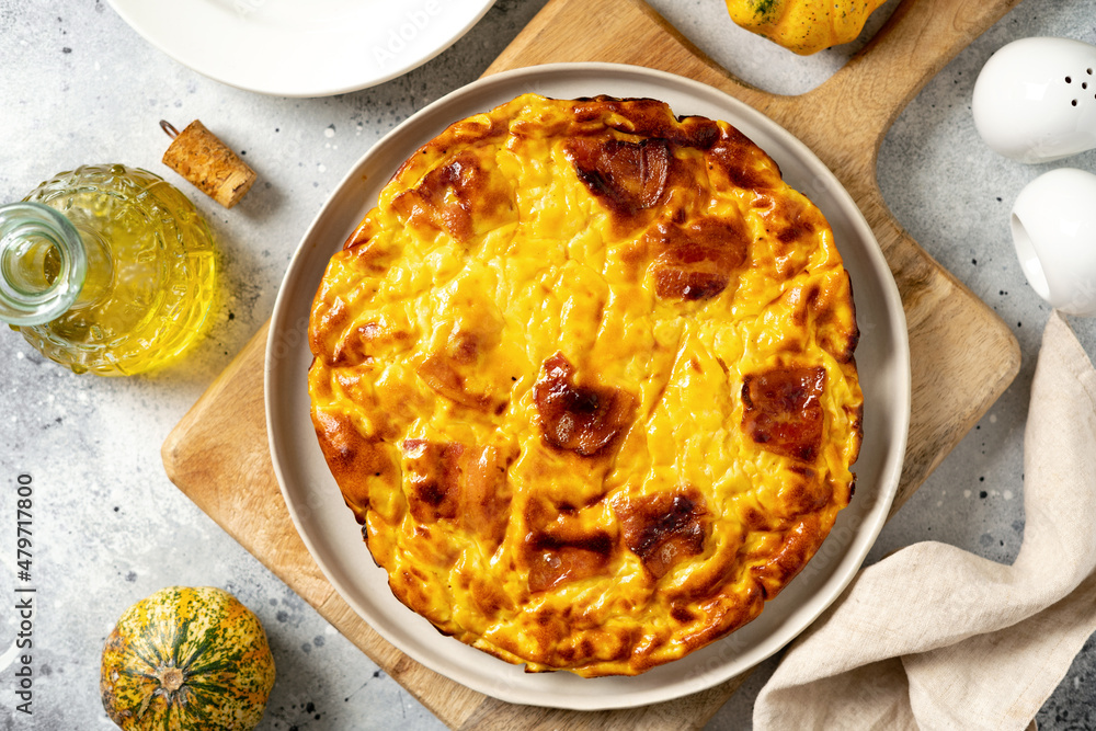 Frittata with pumpkin, bacon and ricotta in a ceramic plate on a light culinary background. Traditional Italian delicious homemade egg dish on the kitchen table top view Frittata with pumpkin, bacon and ricotta in a ceramic plate on a light culinary background. Traditional Italian delicious homemade egg dish on the kitchen table top view