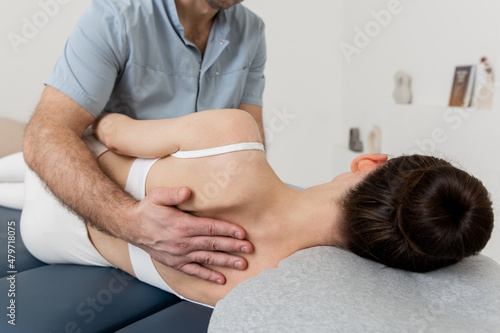 Back massage. Chiropractor or osteopath fixing back during visit in manual therapy clinic. Doctor doing shoulder blade therapy. Scoliosis. Posture Correction. Chiropractic treatment, Back pain relief.