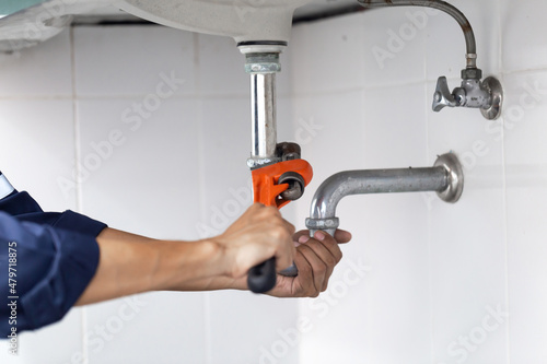 plumber at work in a bathroom, plumbing repair service, assemble and install concept.