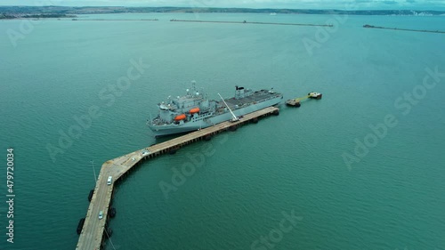Aerial view over Argus Royal fleet auxiliary British military floating hospital ship docked at breakwater harbour