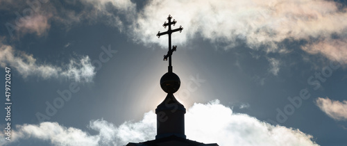 Foto Architecture & Religion: Bell Tower Spire with Christian Cross Against Sky Backlit