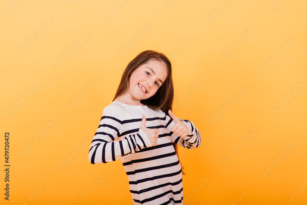 Close-up portrait of a cute little girl. Studio shot over yellow background. Childhood concept. Close-up portrait of a cute little girl. Studio shot over yellow background. Childhood concept.
