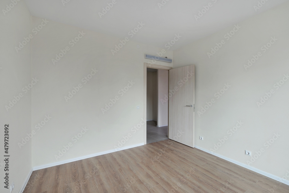 Empty room after repairs in an apartment building. Fresh renovated room with wooden floor Empty room after repairs in an apartment building. Fresh renovated room with wooden floor