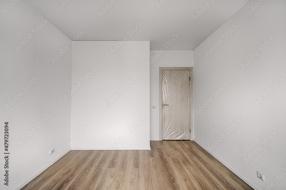 Empty room after repairs in an apartment building. Fresh renovated room with wooden floor Empty room after repairs in an apartment building. Fresh renovated room with wooden floor