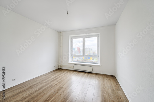 Empty room after repairs in an apartment building. Fresh renovated room with wooden floor