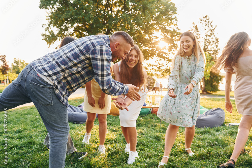 Fototapeta premium Weekend activities. Group of young people have a party in the park at summer daytime