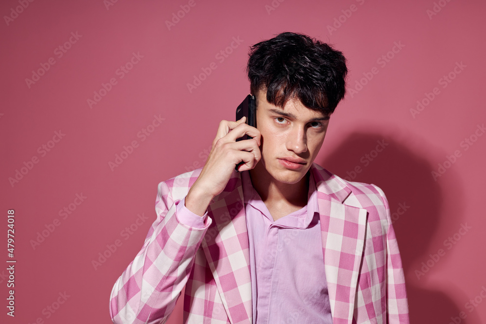 handsome guy with a phone in hand pink blazer fashion elegant style model studio handsome guy with a phone in hand pink blazer fashion elegant style model studio