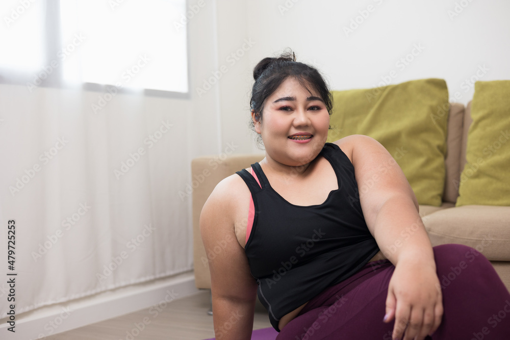 Happy woman plus size sitting exercise with sportswear. Body positive plus size female workout lives happily and is proud of herself smile to camera. Happy woman plus size sitting exercise with sportswear. Body positive plus size female workout lives happily and is proud of herself smile to camera.