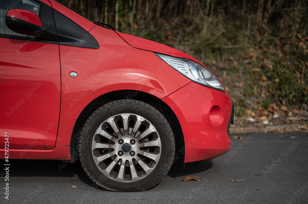 Small red city utility car, side detail wheel