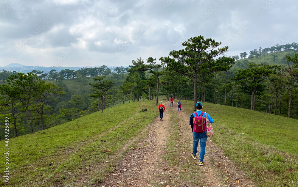 People trekking on the trail leading up to the hill