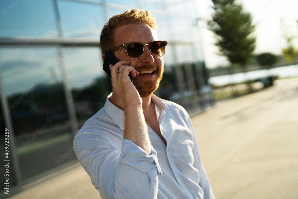 Young happy businessman outdoors. Portrait of handsome man talking to the phone. Young happy businessman outdoors. Portrait of handsome man talking to the phone.
