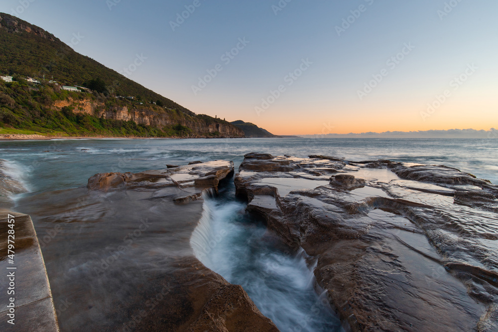 Water flowing between rocks on the beach shore. Water flowing between rocks on the beach shore.