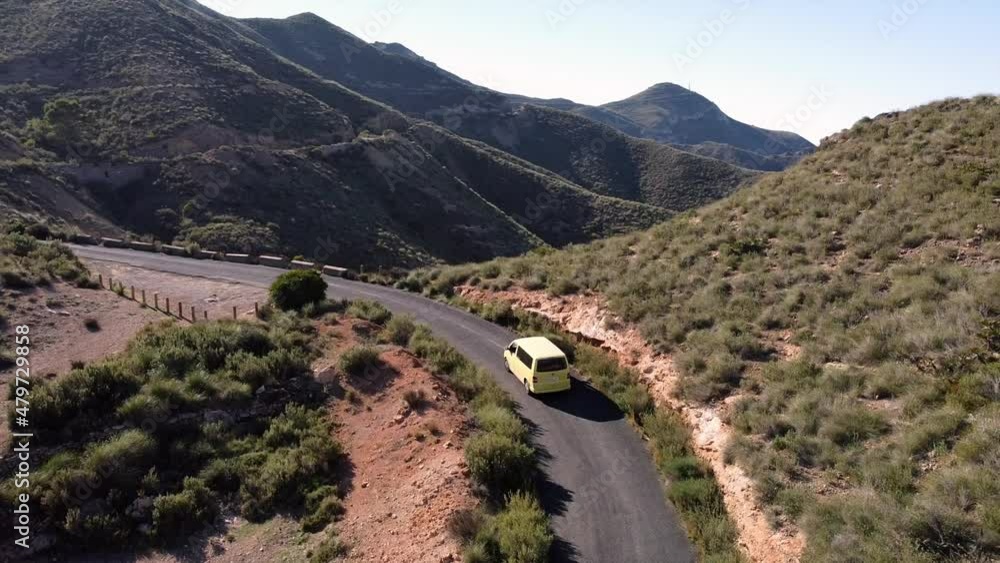 Murcia Spain January 2022 - View from drone of vintage yellow camper van in mountain road - Traveling in freedom in natural landscape with end of lockdown due to Covid-19 Coronavirus epidemic Murcia Spain January 2022 - View from drone of vintage yellow camper van in mountain road - Traveling in freedom in natural landscape with end of lockdown due to Covid-19 Coronavirus epidemic
