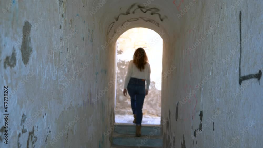 girl walks in a white tunnel and goes to the exit from the door going out of focus girl walks in a white tunnel and goes to the exit from the door going out of focus