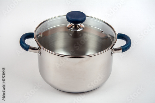Metal saucepan with a glass lid for cooking soup, food. made of stainless steel. kitchen utensils with a thick bottom for electric, infrared, induction or gas stoves. On an isolated white background.
